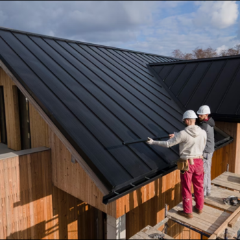 Stout roofing inspecting metal roof installation.